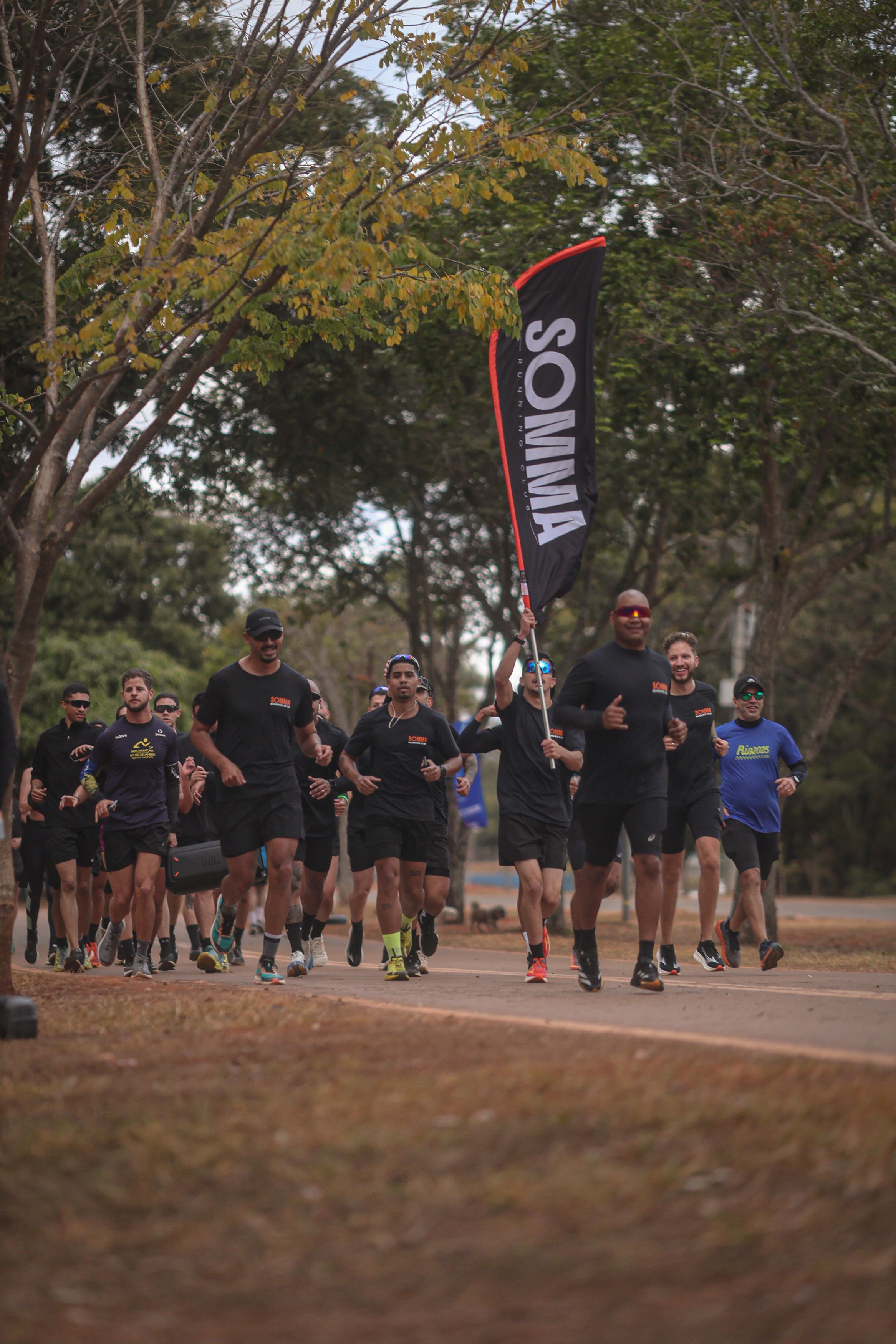 Grupo SOMMA Running Club correndo com bandeira no Parque da Cidade